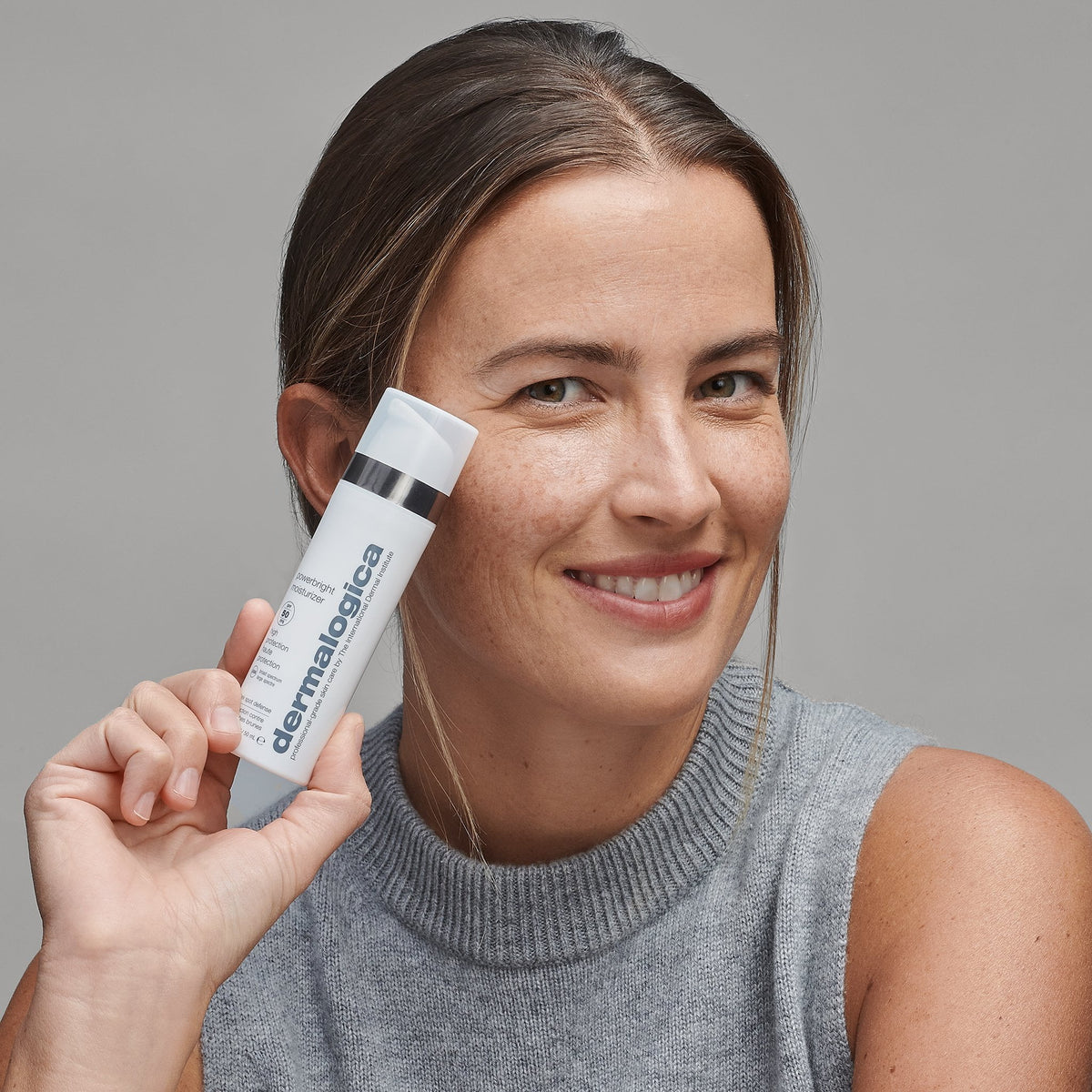 woman holding powerbright moisturizer spf50 